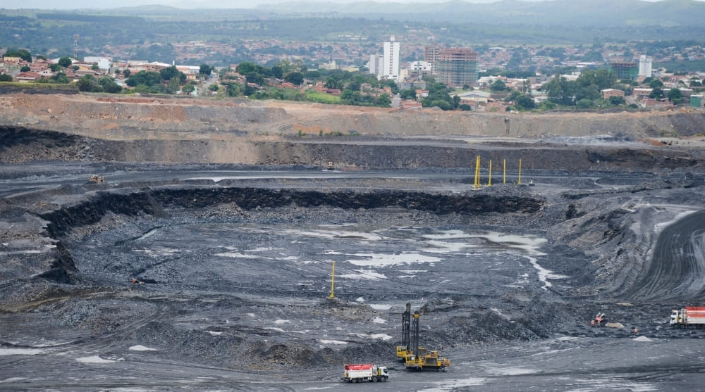 Vista de município minerador com operação de mineração em atividade, destacando desafios sociais e capacidade fiscal das cidades brasileiras.